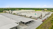 A light colored manufacturing facility and warehouse as seen from above.